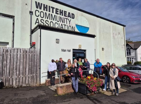 A group of people standing outside the Whitehead Community Association building.